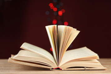 open book on wooden table on bright background