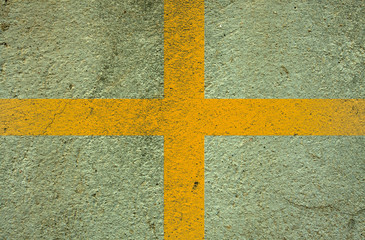 yellow  cross on cement wall background
