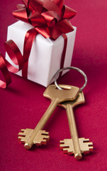 Key with the gift box. House key on a red background.