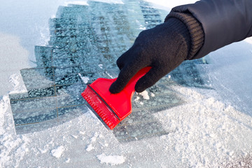 Scraping ice from the car window - Powered by Adobe
