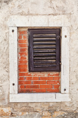Wooden window inside a larger concrete window with bricks inside