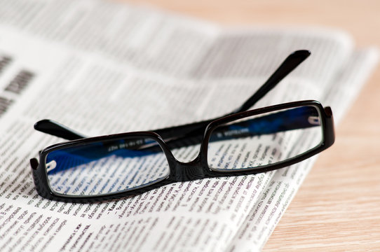 Eyeglasses lying around newspapers