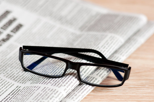 Eyeglasses lying around newspapers