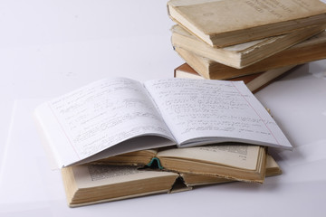 An exercise book on a pile of books