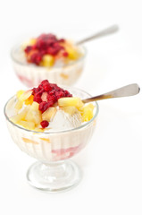 ice cream with fresh berries and pineapple on top on white