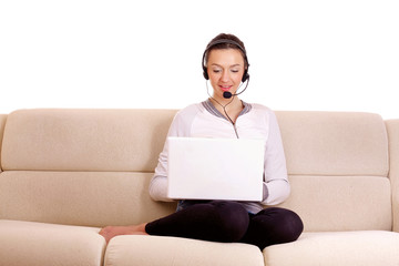 a beautiful girl with laptop sitting of a sofa