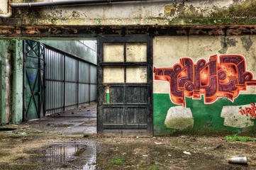 Poster Im Rahmen Wooden door inside an old derelict warehouse © tobago77
