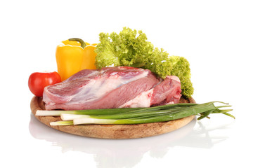 Raw meat and vegetables on a wooden board isolated on whitе