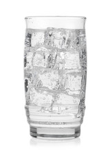 Glass of cold mineral water with ice cubes on white background