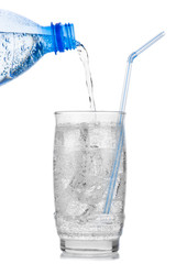 Iced mineral water pouring from plastic bottle into a glass
