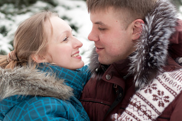 Young lovers woman and man in a winter forest