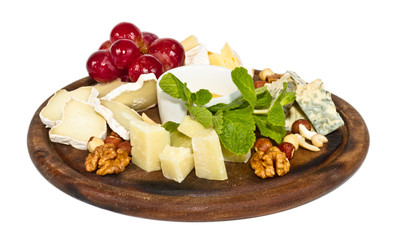 Various types of cheese with honey, nuts and grapes on plate, is