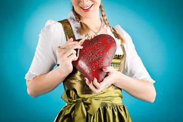 Junge Frau in Dirndl mit Herz in Liebe