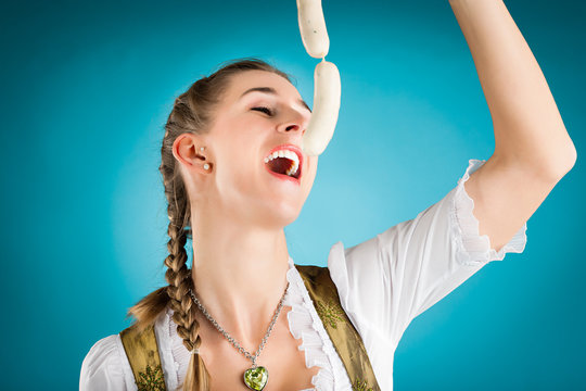 Junge Frau mit Weisswurst im Dirndl