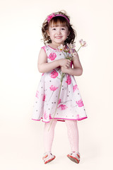 beautiful little girl in a dress with a flower in your hand