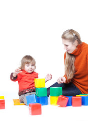 Mum with a small daughter cubes, studio shooting play