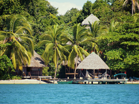 Eco resort on a Caribbean beach with thatched huts and lush tropical vegetation, Bocas del Toro, Panama, Central America