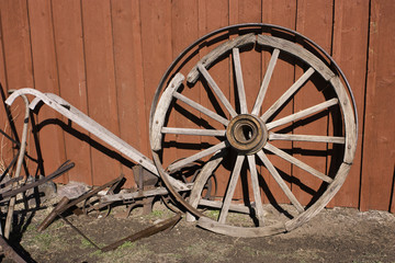 Obraz premium red barn with wheel and plow