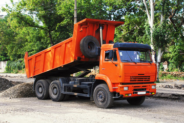 Fototapeta na wymiar Pomarańczowy wózek przemysłowy na drodze constraction