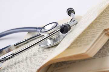 a stethoscope on an opened book, closeup - obrazy, fototapety, plakaty