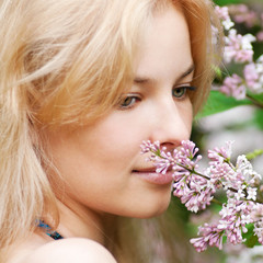 Obraz na płótnie Canvas Woman with lilac flower on face
