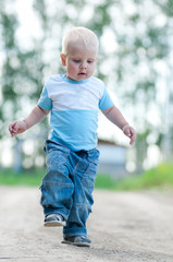 Happy little boy in the green park