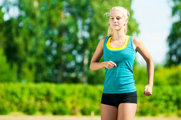 Young woman running in green park