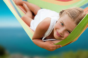 Summer vacation - Lovely  girl resting in colorful hammock