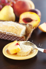 peach, pear, plum, coconut cake,spoon and grapes on a wooden tab