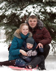 Obraz premium Family walking in the park during the winter snowfall