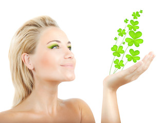 Beautiful woman holding clover leaves