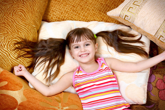 happy child girl resting on soft pillow