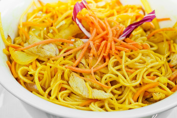 Curry chicken made with carrots, onions and noodles in wok