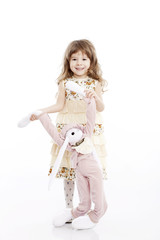 Portrait of a smiling little girl playing with a toy rabbit