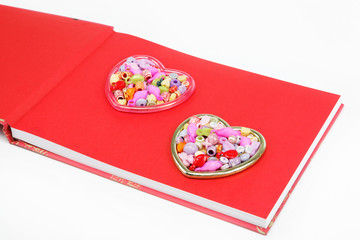 Two hearts from colored beads on a red background