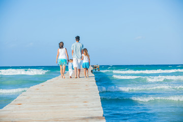 Family of four on wooden jetty by the ocean