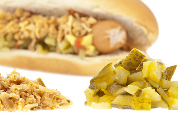 Blurred hot-dog in the background and ingredients in front