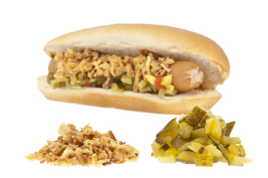 Blurred hot-dog in the background and ingredients in front