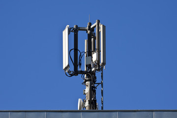 Mobilfunkantenne auf Dach, blauer Himmel