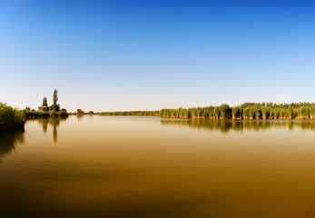 Fototapeta premium Village with pasture near the blue river