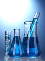 Test-tubes with blue liquid on blue background