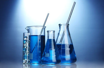 Test-tubes with blue liquid on blue background