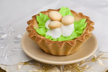 Cake with decorative mushrooms on an embroidered napkin