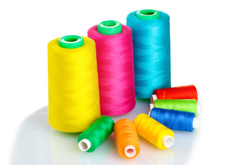 Many-coloured bobbins of thread isolated on white