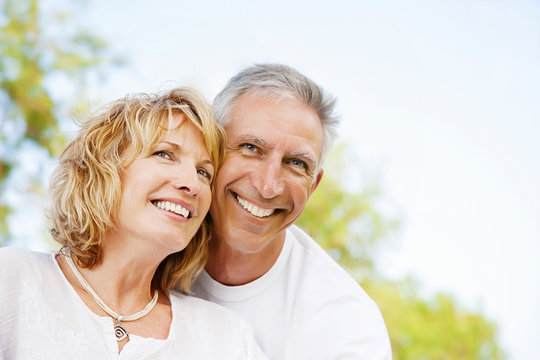 Mature couple smiling and embracing.