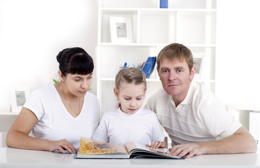 Obraz na płótnie Canvas Family reading a book together