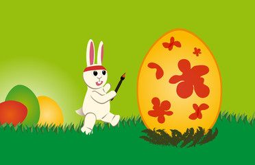 weißer Osterhase bemalt wie wild ein Osterei