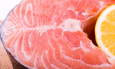 Piece of a salmon with lemon on a white background