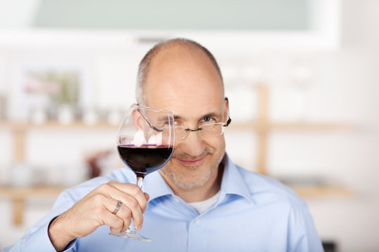 mann prostet mit einem glas rotwein