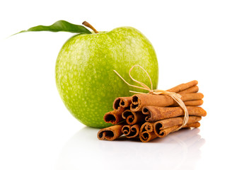 Ripe green apple with cinnamon sticks isolated